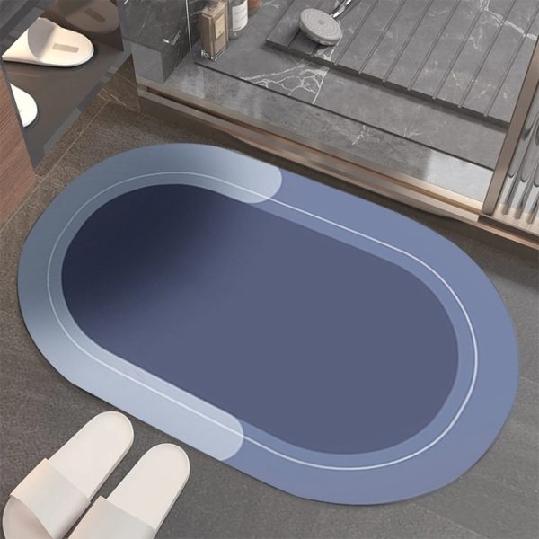 Ce tapis est ovale . Il est placé devant une douche avec des chaussons. Il est bleu.
