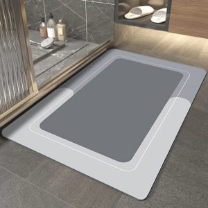 Ce tapis est rectangulaire . Il est placé devant une douche avec des chaussons. Il est gris.