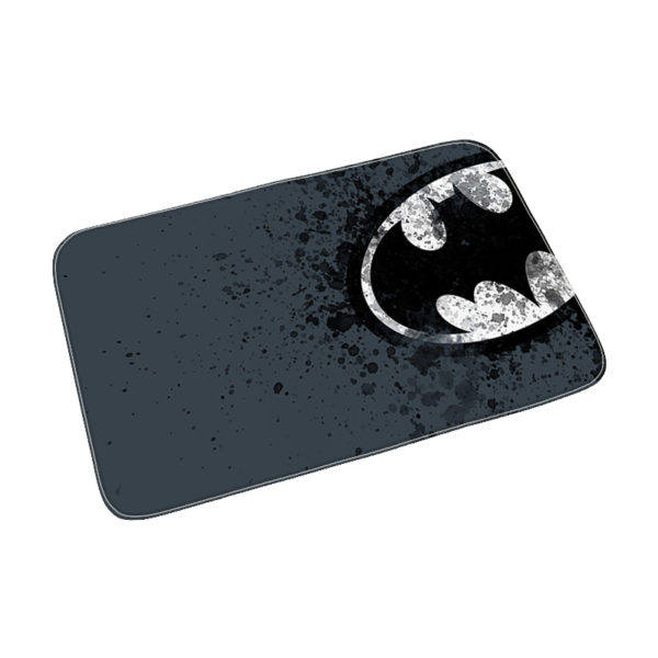 Paillasson rectangulaire sombre avec le logo batman à droite dans un ovale blanc en tache d'encre
