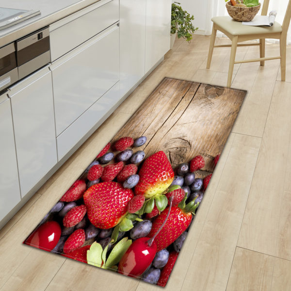 Tapis marron avec un côté rempli de fruits rouges. Parquet marron clair et meubles de cuisine blancs.