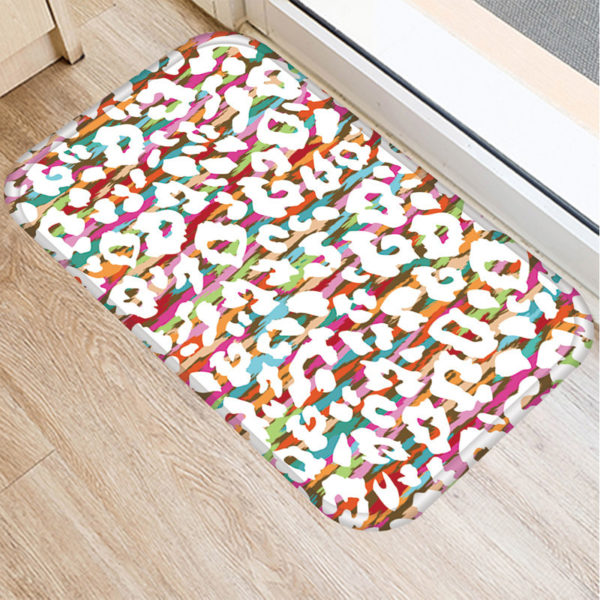 Un paillasson imprimé multicolore avec des taches léopar posé ur un parquet
