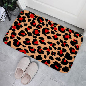 Paillasson imprimé motifs leopard a taches rouges pose devant une porte avec des chaussons a cote