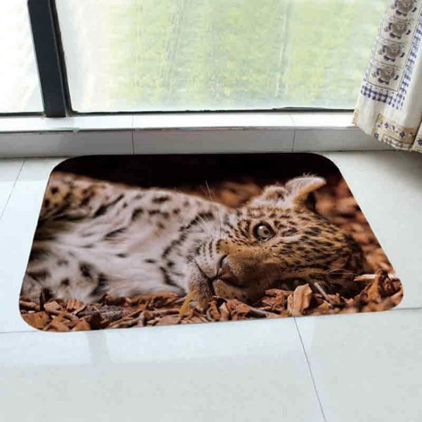 Paillasson imprime d'un bebe leopard devant une fenetre sur du carrelage