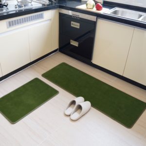 2 paillassons verts rectangulaires dans une cuisine. Sol blanc et chaussons posés.
