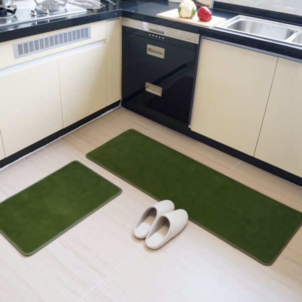 2 paillassons verts rectangulaires dans une cuisine. Sol blanc et chaussons posés.