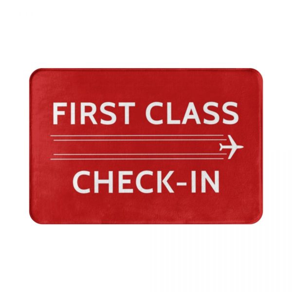Un paillasson rouge rectangulaire avec le message "FIRST CLASS CHECK-IN" et un design d'avion sur un fond blanc.