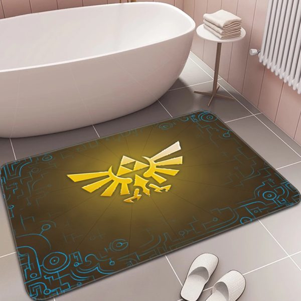 Dans une salle de bain à carrelage ivoire, un paillasson est posé devant une baignoire et à côté de chaussons blancs. Le paillasson est marron et bleu avec le symbole de la Triforce en jaune.